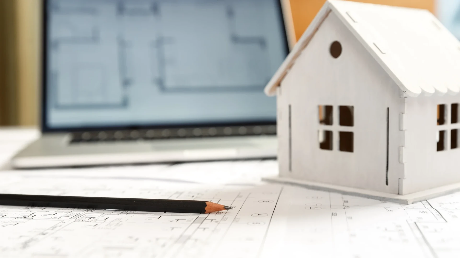 Hausmodell auf Bauplänen – Immobilienverkauf mit RGI Immobilien in Pfronten, Füssen und Kempten, Beratung für Eigentümer und Investoren